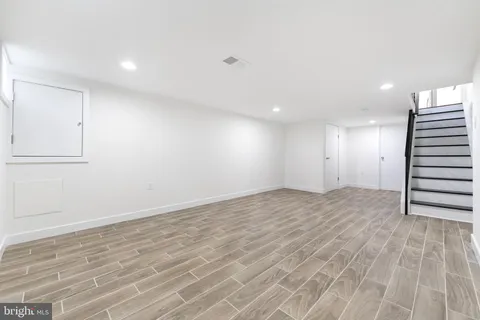 a view of an empty room with wooden floor and entryway