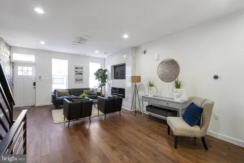 a living room with fireplace furniture and a wooden floor