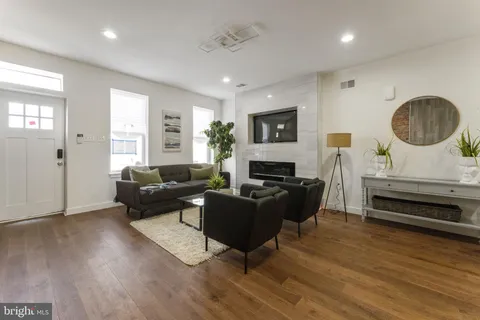 a living room with furniture and a wooden floor