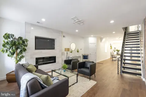 a living room with furniture fireplace and potted plants
