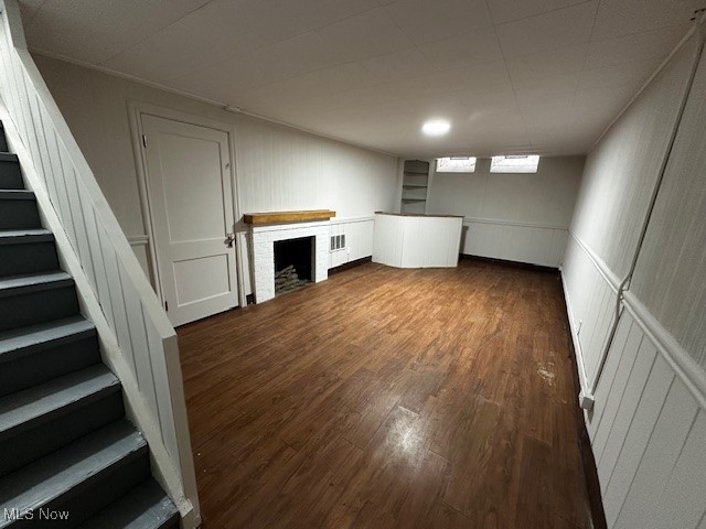 1171 Pennfield Road Cleveland, OH 44121 - Photo 24 of 26 Below grade area with a decorative wall, dark wood finished floors, stairway, wainscoting, and a fireplace