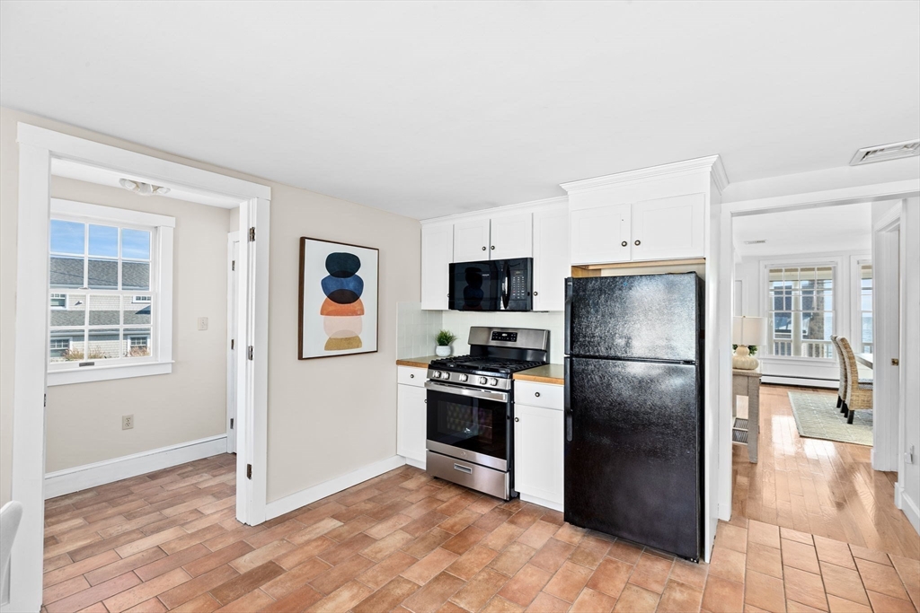 50 Collier Road Scituate, MA 02066 - Photo 11 of 41 a kitchen with stainless steel appliances granite countertop a refrigerator a stove and a sink with wooden floor
