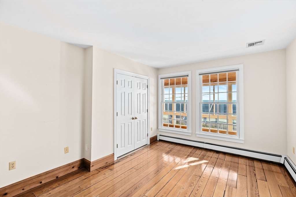50 Collier Road Scituate, MA 02066 - Photo 31 of 41 an empty room with wooden floor and windows