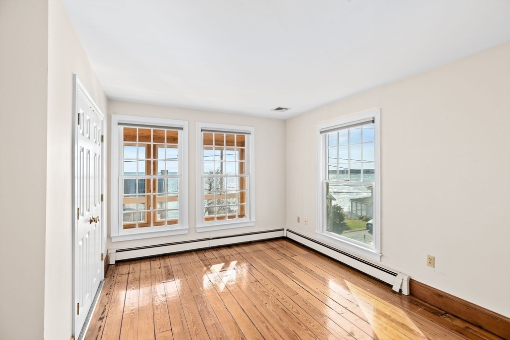 50 Collier Road Scituate, MA 02066 - Photo 32 of 41 an empty room with wooden floor and windows