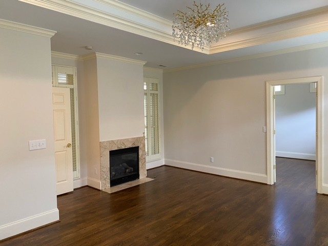 104 Gardengate Drive Franklin, TN 37069 - Photo 4 of 9 an empty room with wooden floor fireplace and chandelier