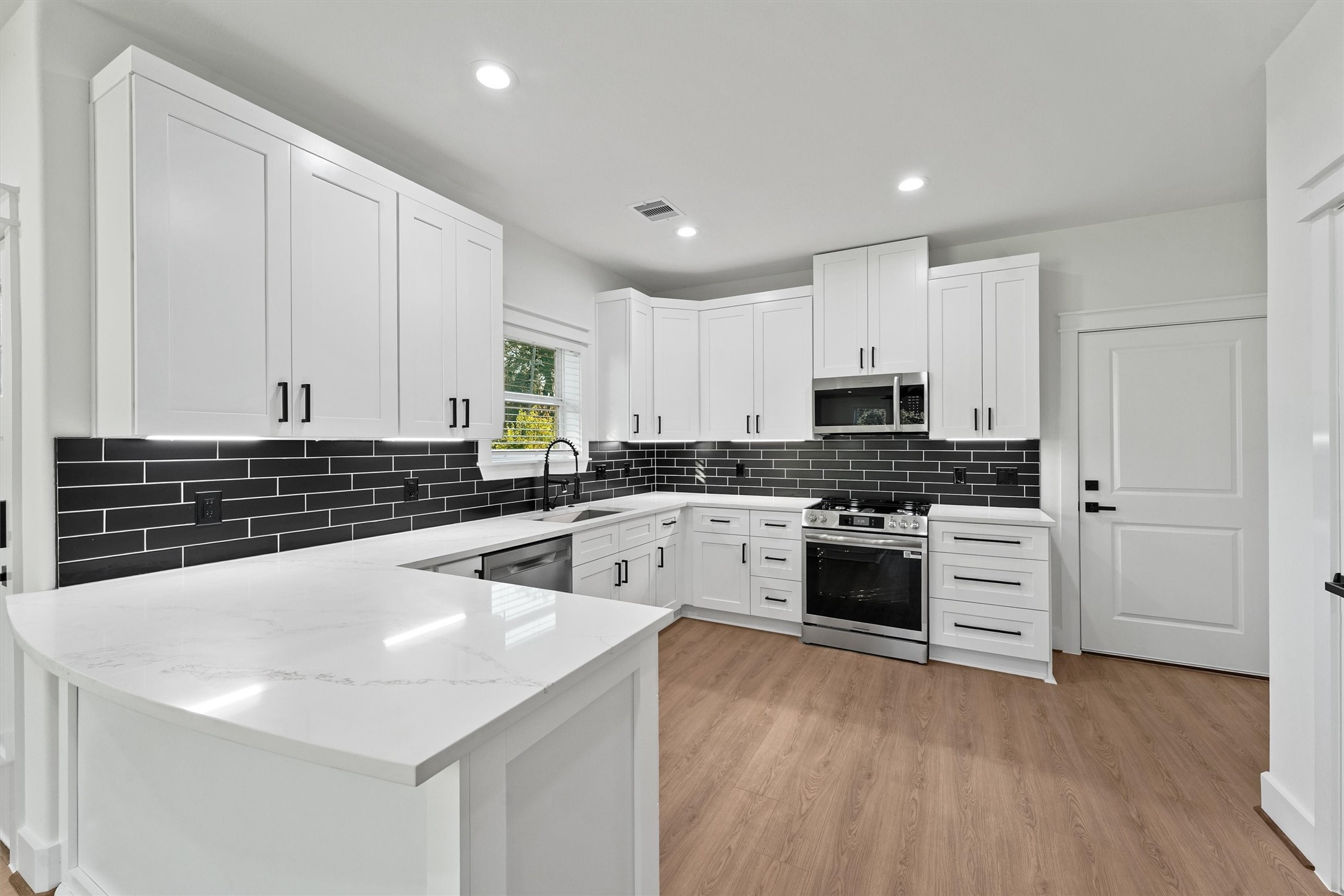 4208 Castor Street, Unit B Houston, TX 77022 - Photo 4 of 23 a kitchen with granite countertop white cabinets and white appliances