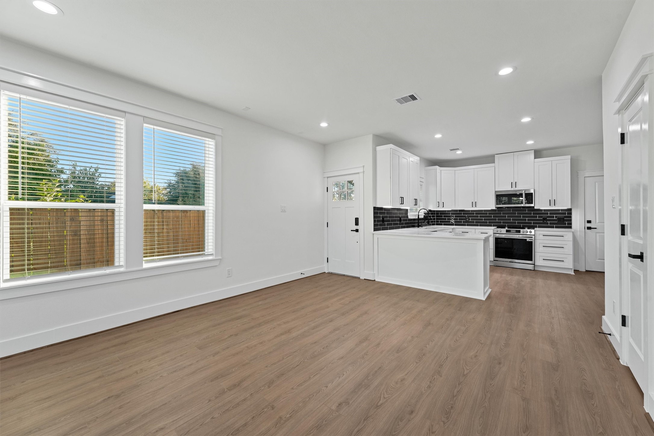4208 Castor Street, Unit B Houston, TX 77022 - Photo 7 of 23 a view of kitchen with granite countertop refrigerator oven sink and white cabinets with wooden floor
