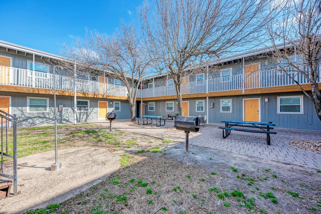 2401 Manor St Road, Unit 118 Austin, TX 78722 - Photo 16 of 17 a view of a building with a yard and sitting area
