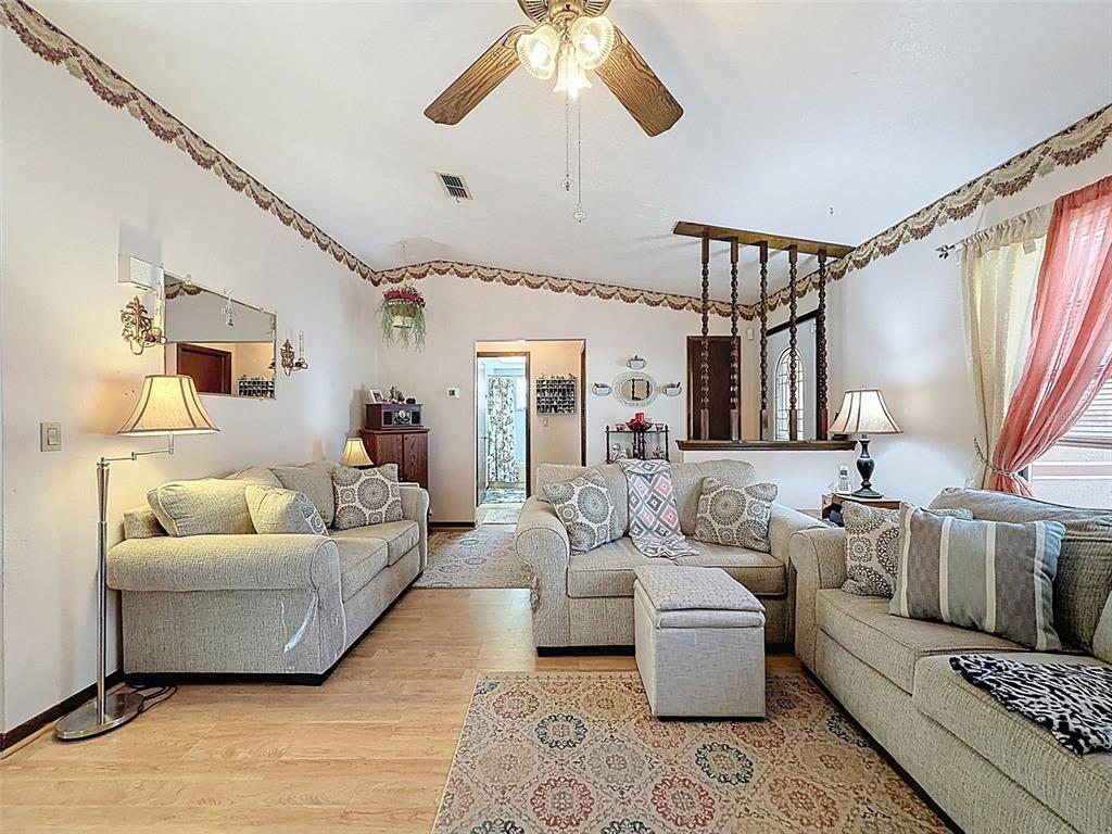12229 Cedro Street Spring Hill, FL 34609 - Photo 12 of 50 a living room with furniture and a chandelier