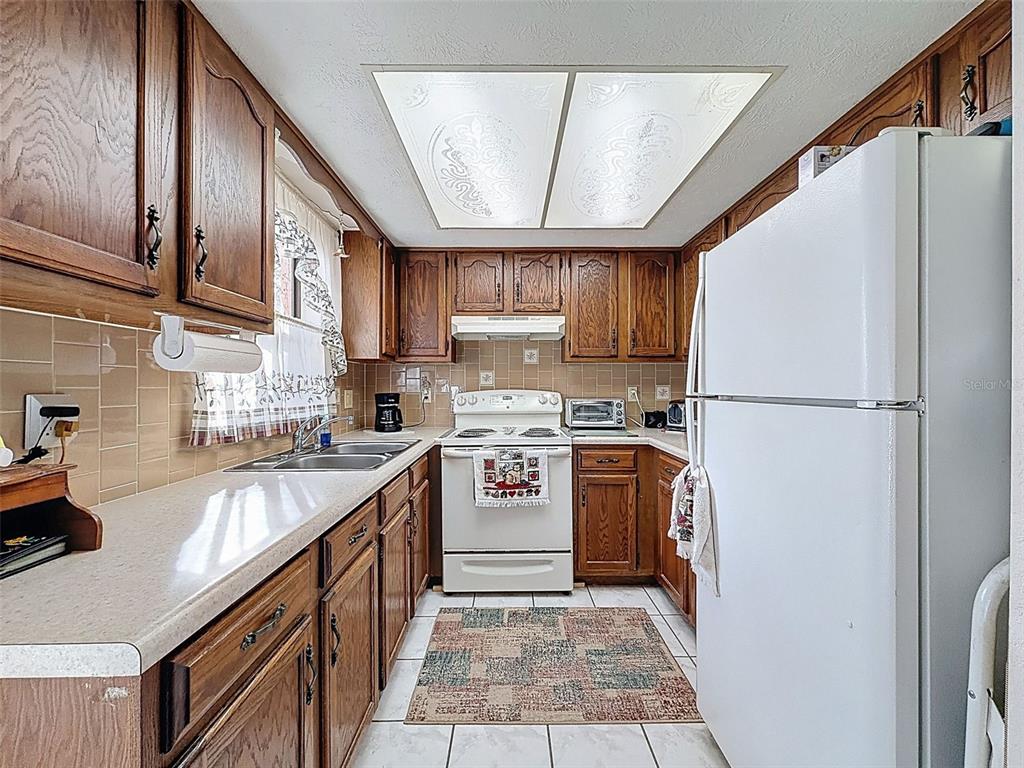 12229 Cedro Street Spring Hill, FL 34609 - Photo 17 of 50 a kitchen with stainless steel appliances granite countertop a refrigerator a sink dishwasher a stove top oven a refrigerator and cabinets
