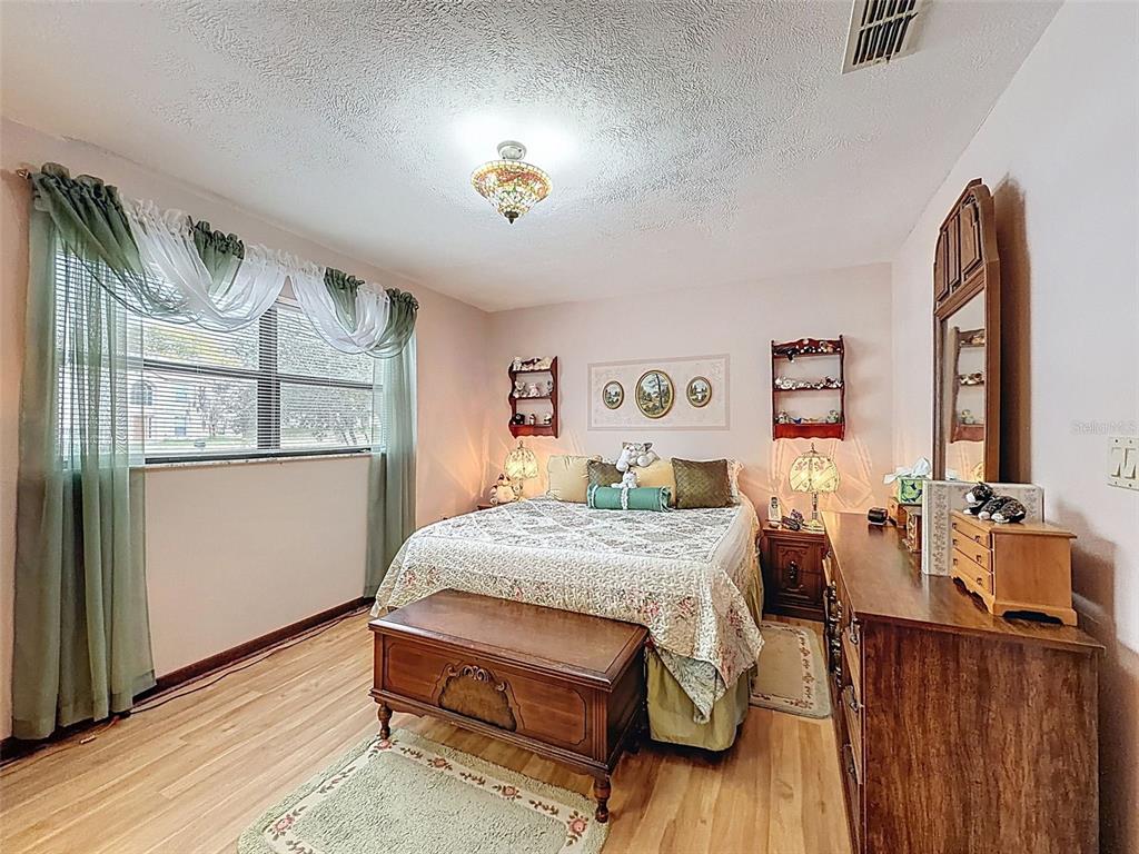 12229 Cedro Street Spring Hill, FL 34609 - Photo 21 of 50 a bedroom with a bed and wooden floor