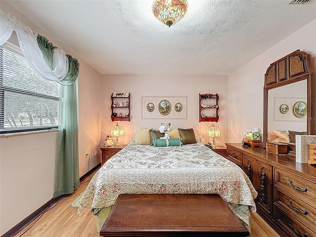 12229 Cedro Street Spring Hill, FL 34609 - Photo 22 of 50 a bedroom with a large bed and a dresser