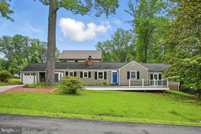 a front view of a house with a garden and lake view