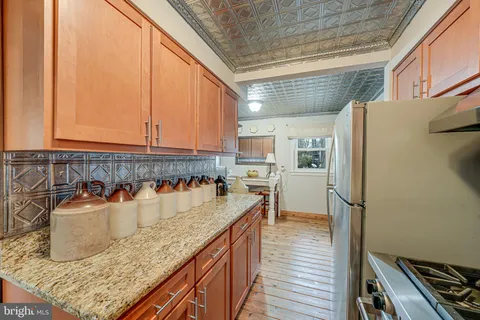 a kitchen with stainless steel appliances granite countertop a refrigerator and a stove
