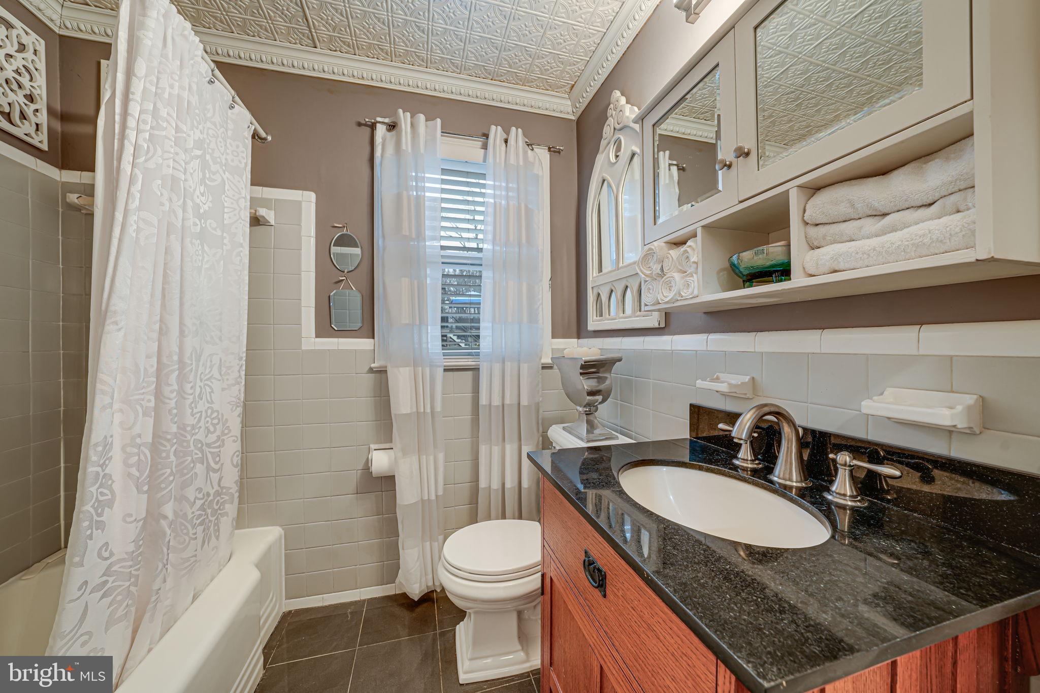 8536 Aponi Road Vienna, VA 22180 - Photo 18 of 40 a bathroom with a granite countertop sink toilet and shower
