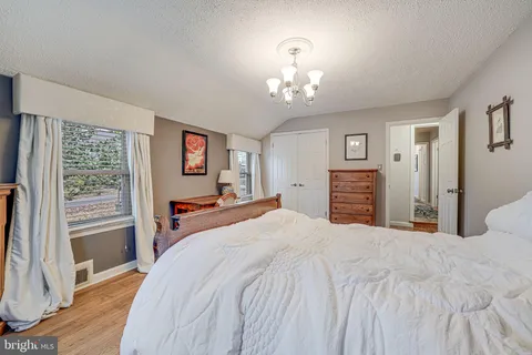 a bedroom with a bed wooden floor and window