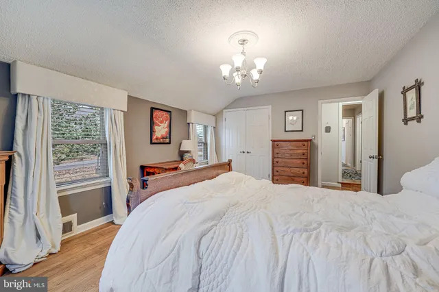 a bedroom with a bed wooden floor and window