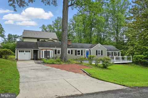 a front view of a house with a yard and trees