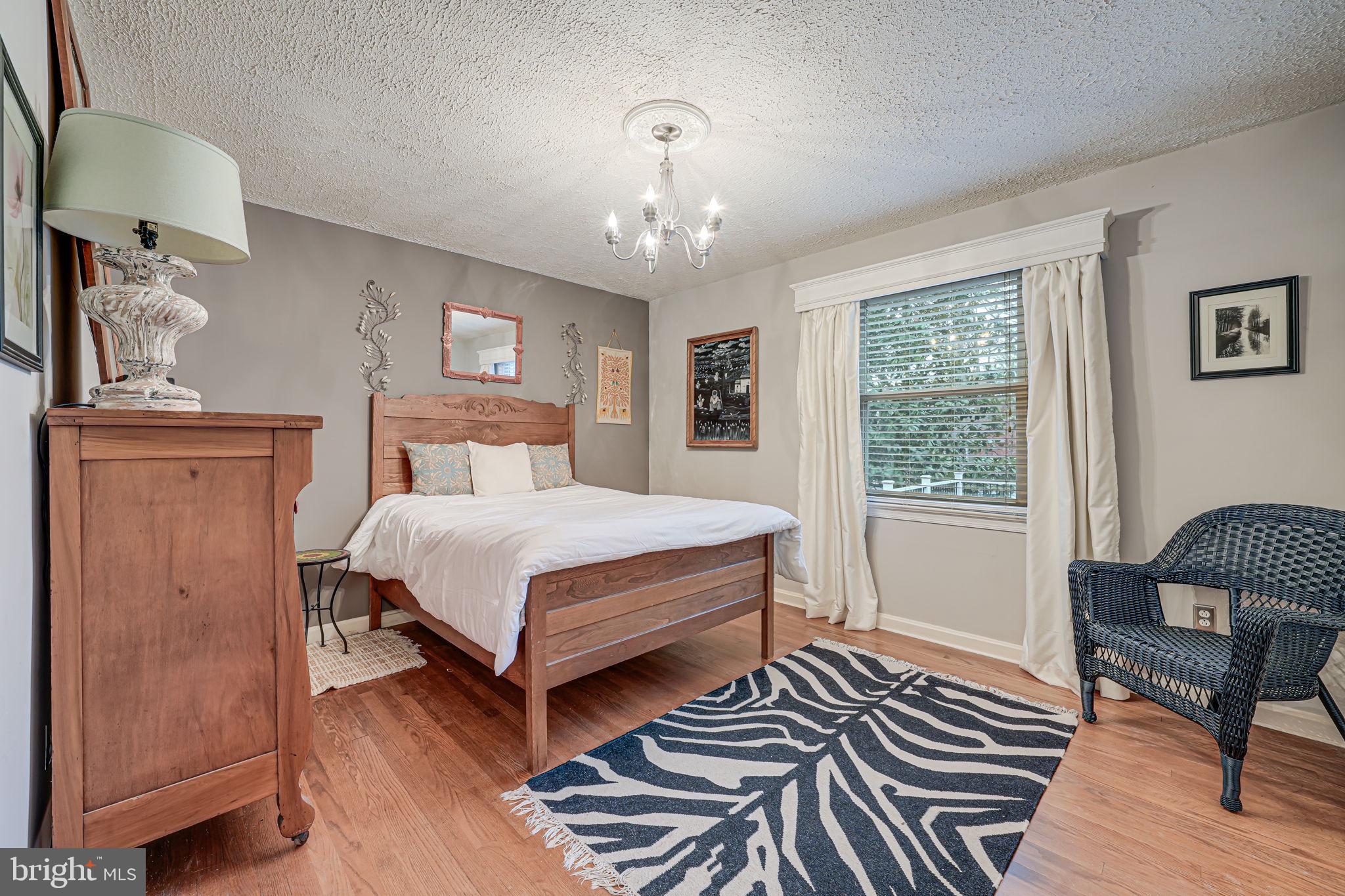8536 Aponi Road Vienna, VA 22180 - Photo 21 of 40 a bedroom with a bed wooden floor and window