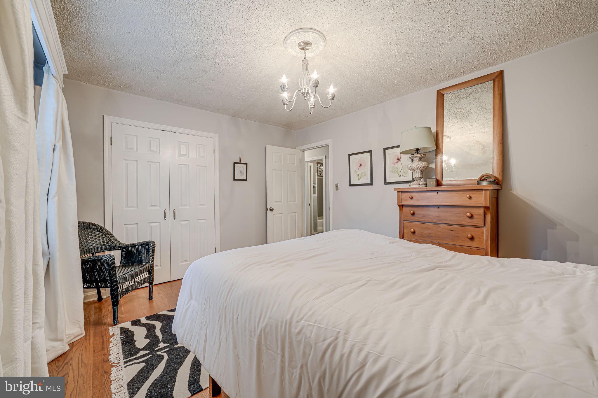 8536 Aponi Road Vienna, VA 22180 - Photo 22 of 40 a bedroom with a bed and a chandelier