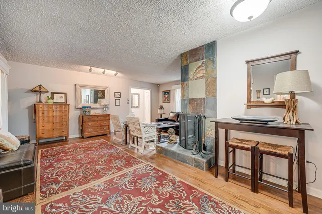 a living room with furniture a rug and kitchen view