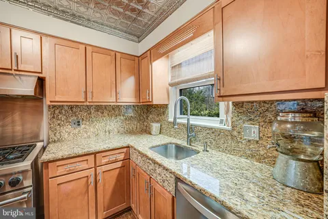 a kitchen with stainless steel appliances granite countertop a sink stove and cabinets
