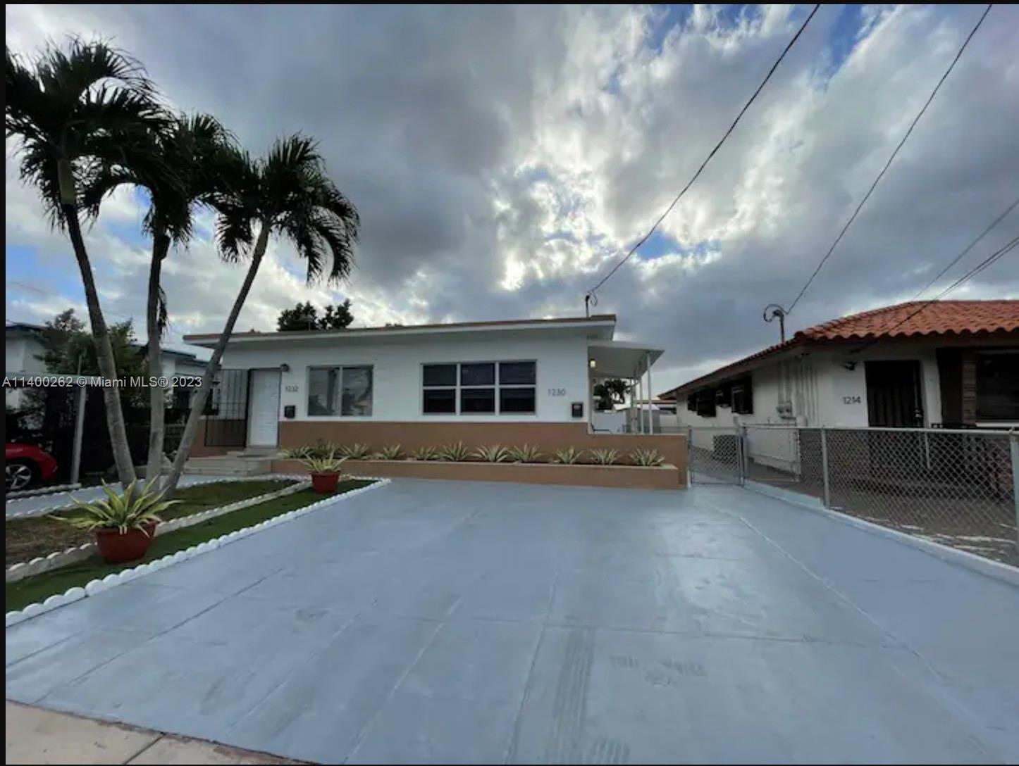 a view of a house with a patio and a yard