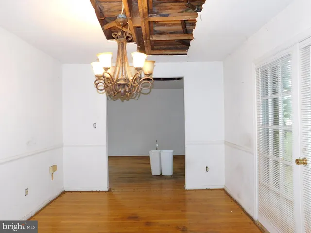 a view of a room with wooden floor and chandelier