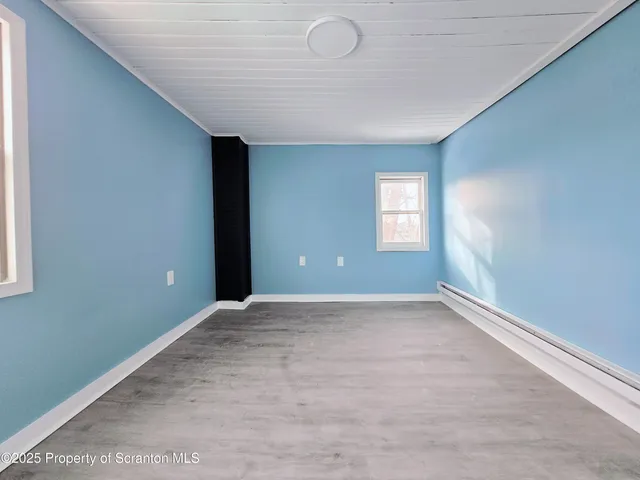 an empty room with windows and closet