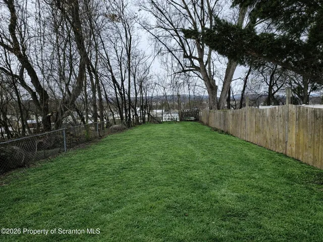 a view of a park with trees in the background