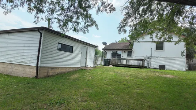 a backyard of a house with table and chairs