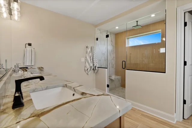 a bathroom with a sink toilet a mirror and shower