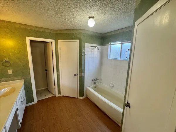a bathroom with a tub shower and sink