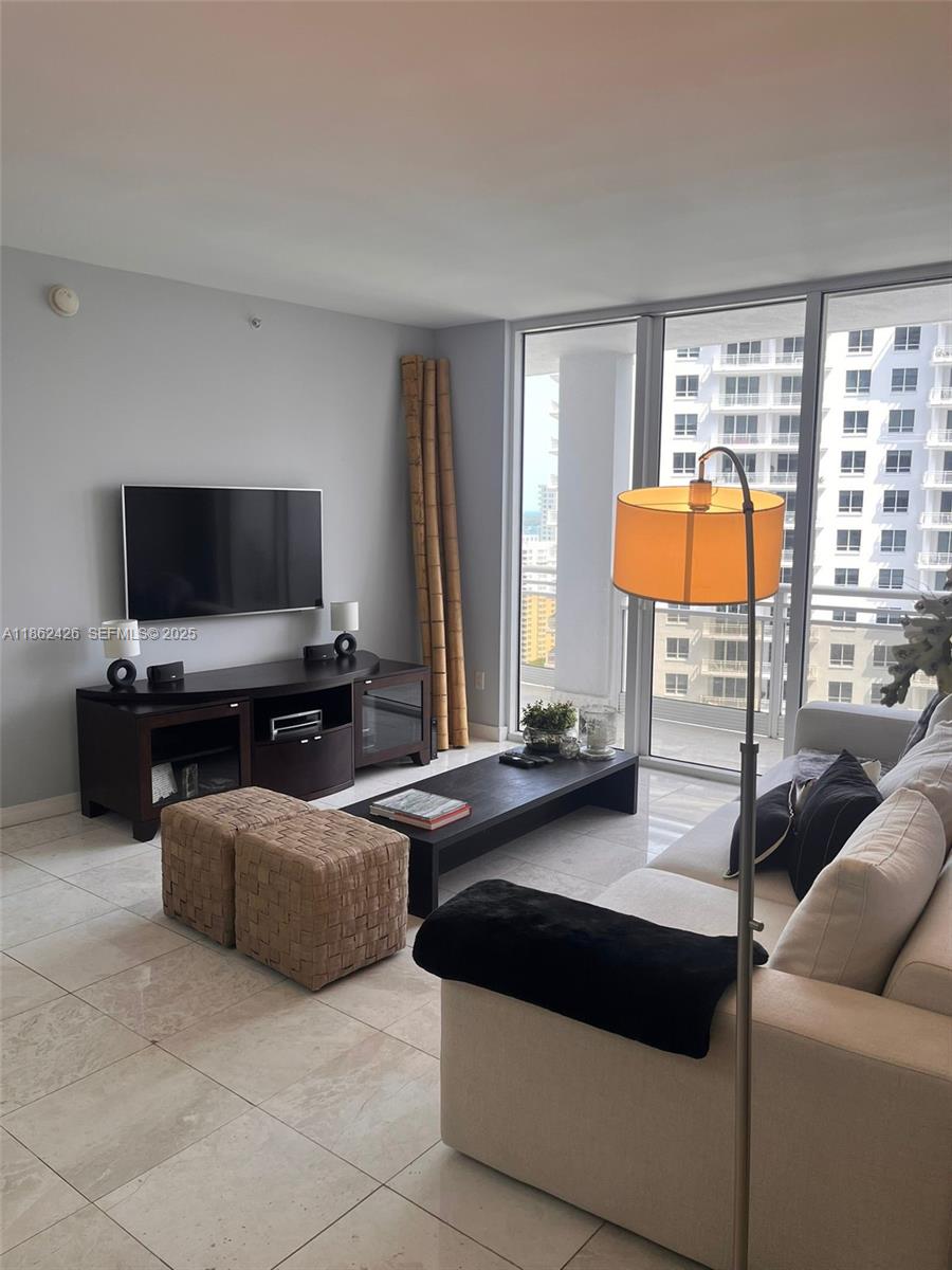 901 Brickell Key Boulevard, Unit 2701 Miami, FL 33131 - Photo 3 of 30 a living room with furniture and a flat screen tv