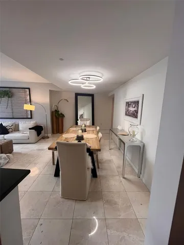 a living room with couches a coffee table and painting on the wall