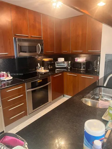 a kitchen with stainless steel appliances wooden cabinets and a stove top oven