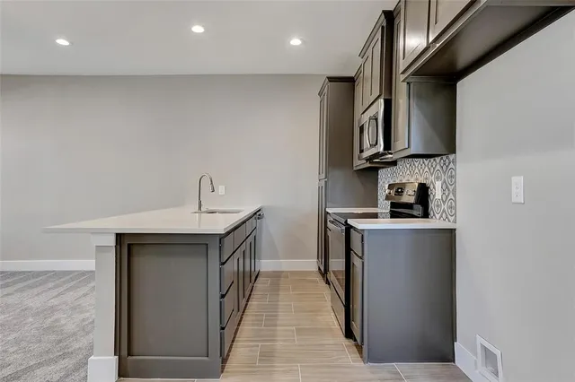a kitchen with stainless steel appliances granite countertop a sink a stove and cabinets