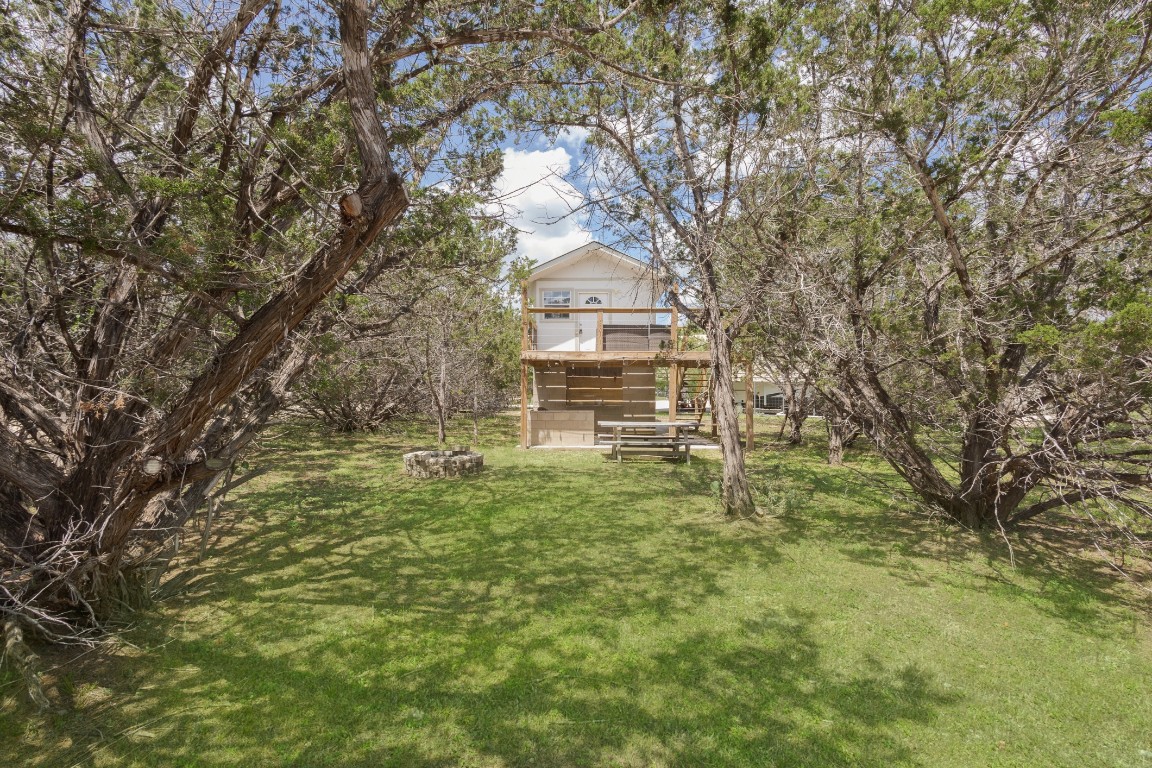 539 Rio Luna Drive Bandera, TX 78003 - Photo 19 of 24 a yellow house with trees in front of it