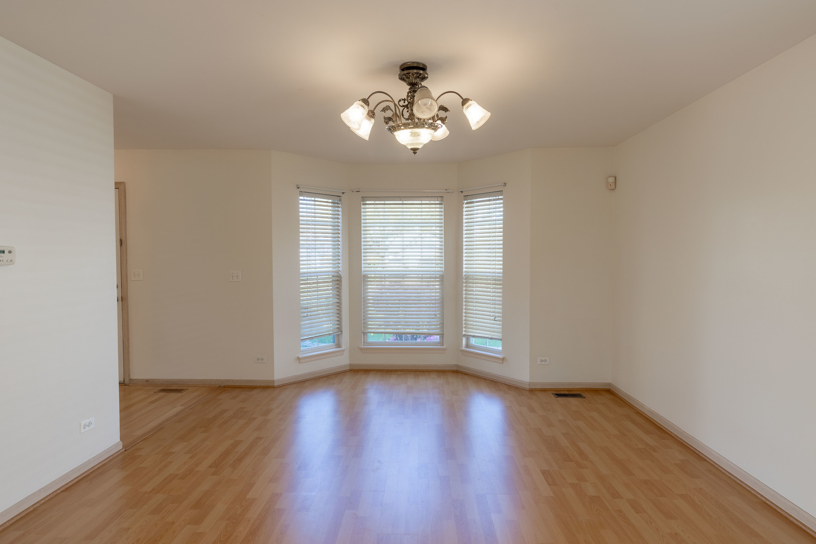 643 Maple Drive Streamwood, IL 60107 - Photo 5 of 32 a view of an empty room with wooden floor and a window