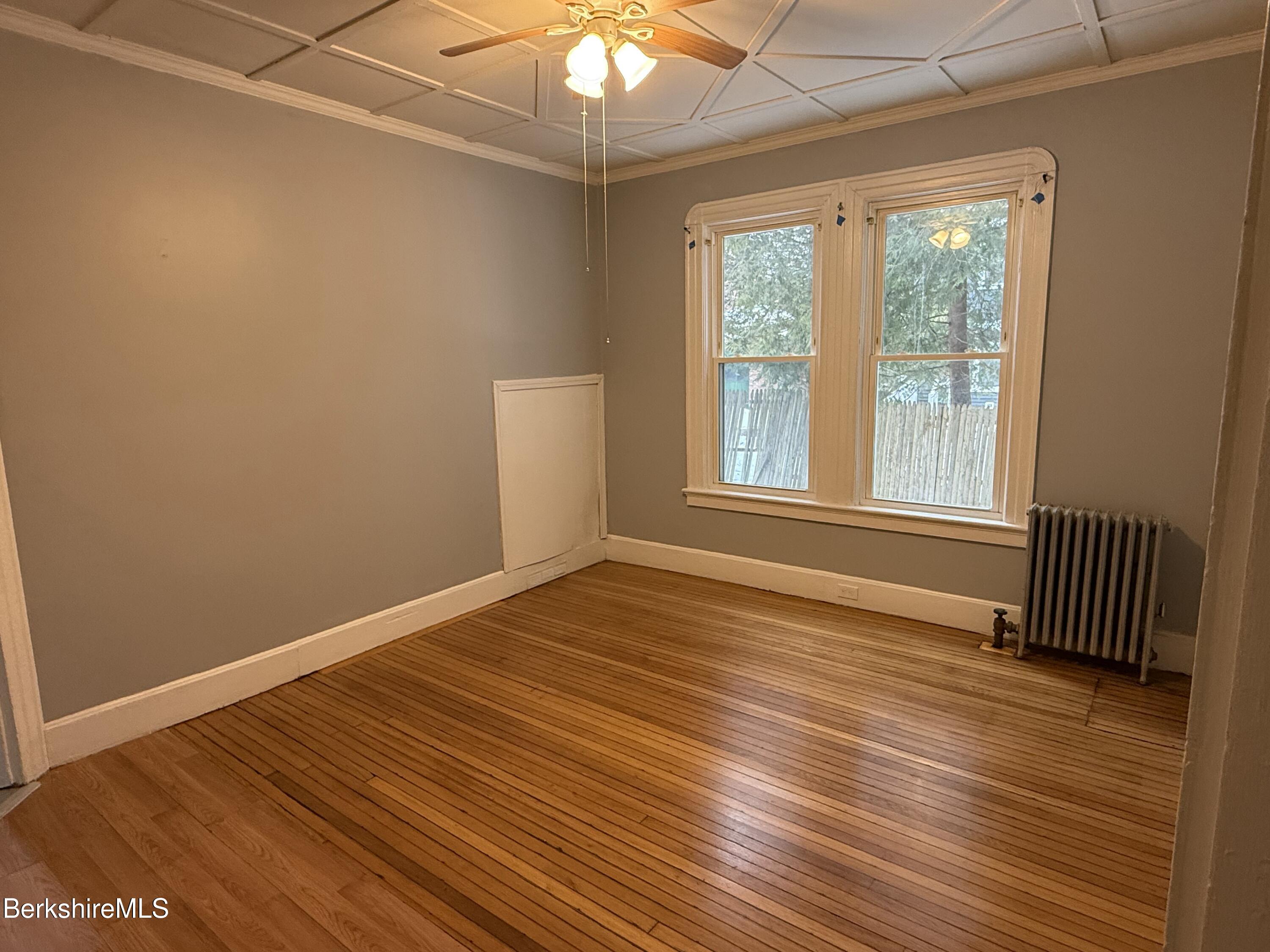124 Appleton Avenue, Unit 1 Pittsfield, MA 01201 - Photo 2 of 10 a view of an empty room with wooden floor and a window