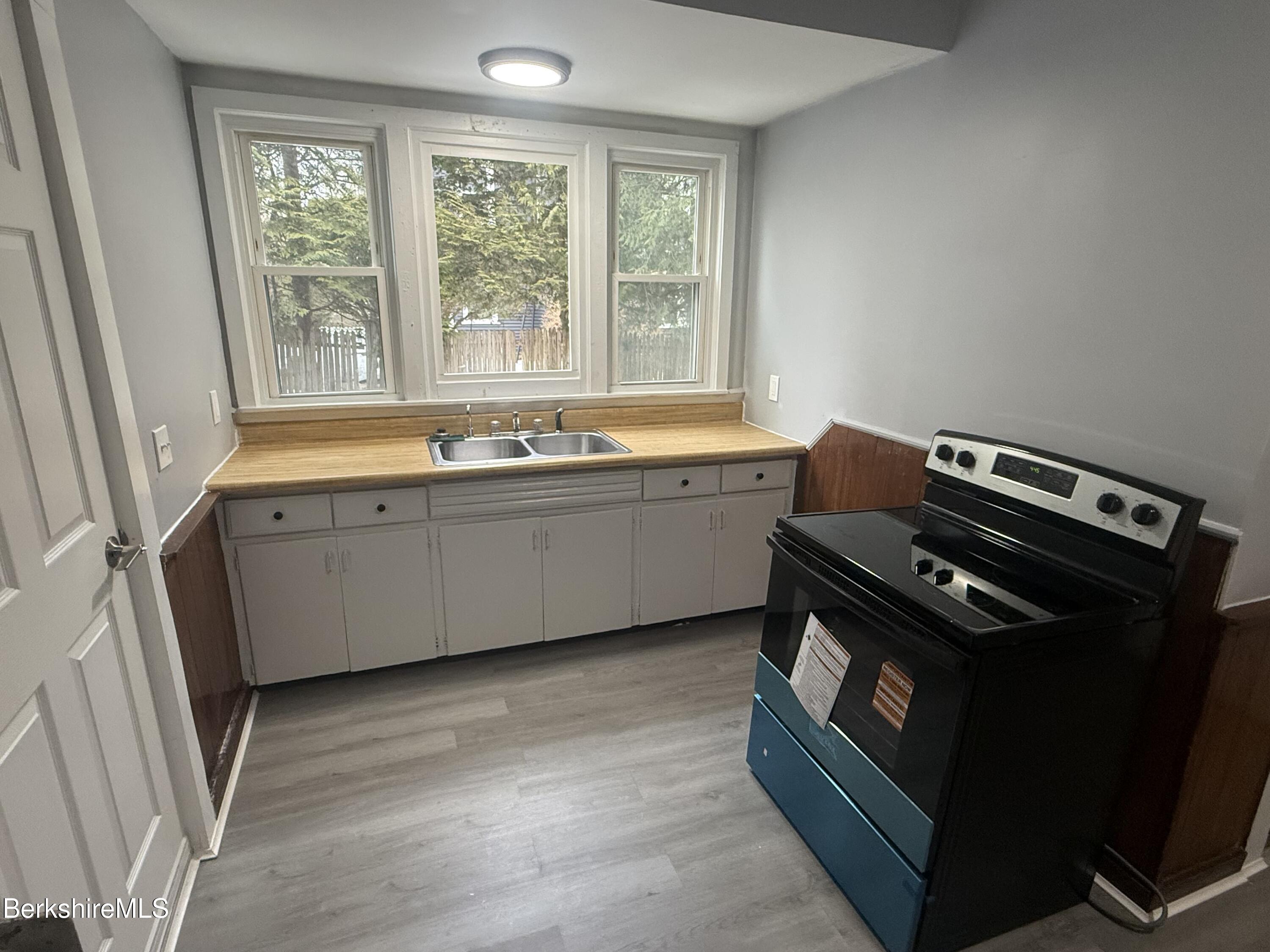 124 Appleton Avenue, Unit 1 Pittsfield, MA 01201 - Photo 3 of 10 a view of a kitchen with a sink a window and wooden floor