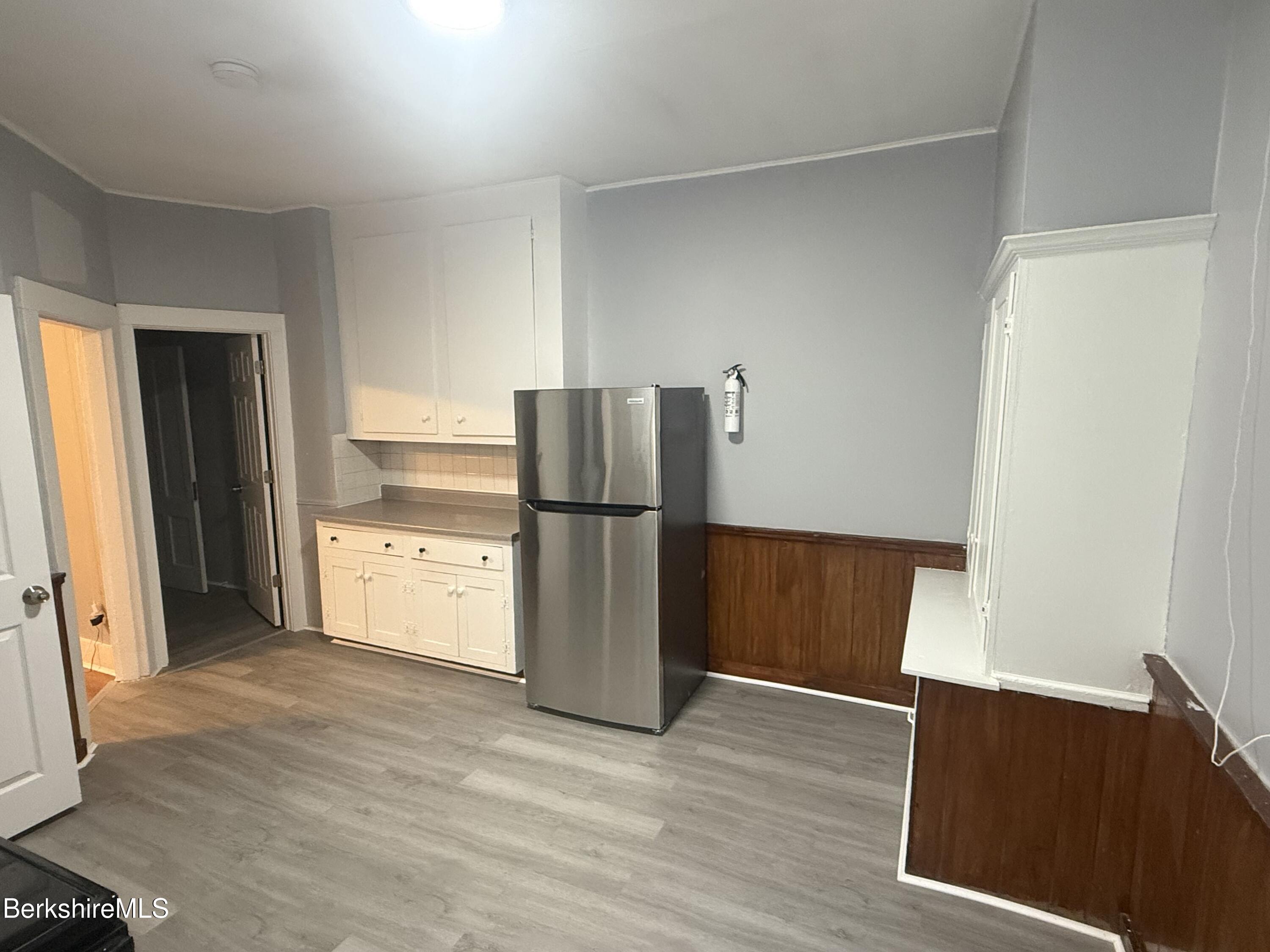 124 Appleton Avenue, Unit 1 Pittsfield, MA 01201 - Photo 4 of 10 a kitchen with a refrigerator and a wooden floor