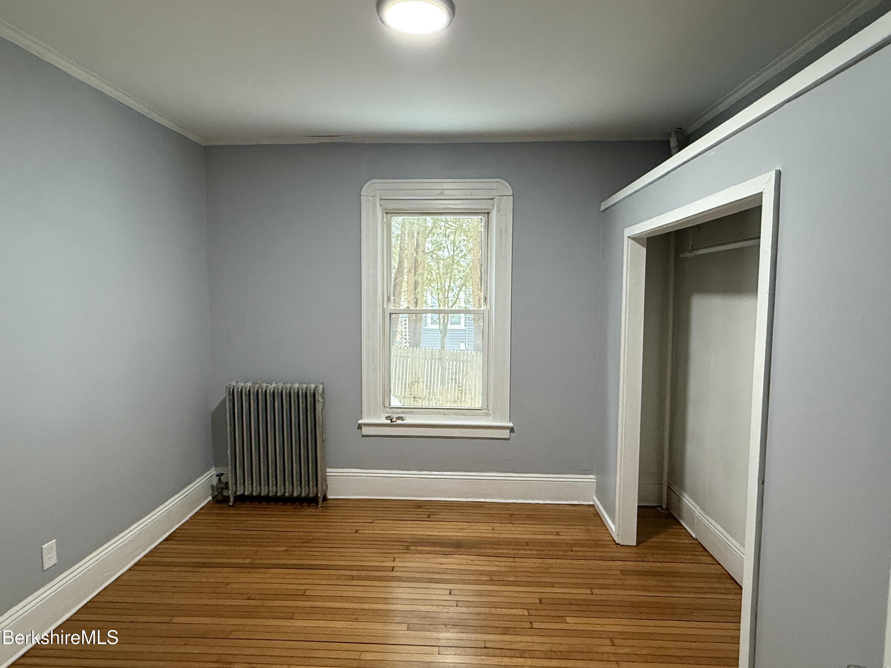 124 Appleton Avenue, Unit 1 Pittsfield, MA 01201 - Photo 7 of 10 an empty room with wooden floor and windows
