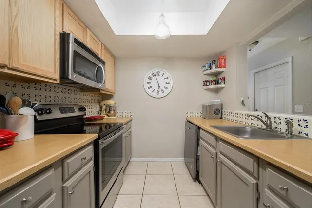 a kitchen with a sink dishwasher stove and cabinets