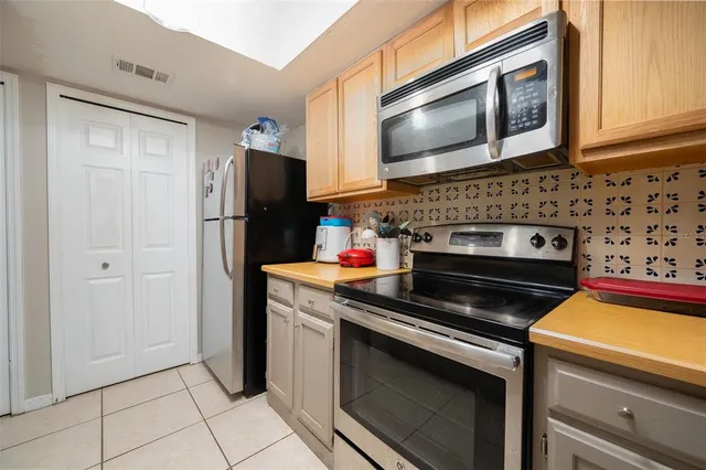 a kitchen with stainless steel appliances granite countertop a stove microwave and refrigerator