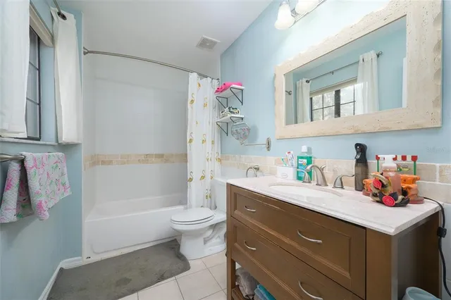 a bathroom with a sink vanity mirror bathtub and toilet