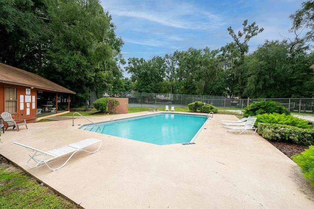 900 Southwest 62nd Boulevard, Unit H49 Gainesville, FL 32607 - Photo 27 of 38 a view of swimming pool with a patio and a yard
