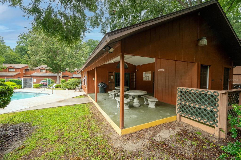 900 Southwest 62nd Boulevard, Unit H49 Gainesville, FL 32607 - Photo 31 of 38 a view of a patio with table and chairs and floor to ceiling window