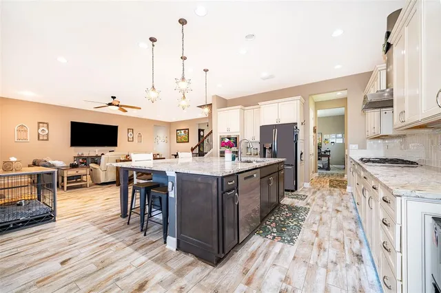 a large kitchen with stainless steel appliances kitchen island granite countertop a large island in the center