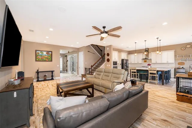 a living room with furniture and a flat screen tv with kitchen view